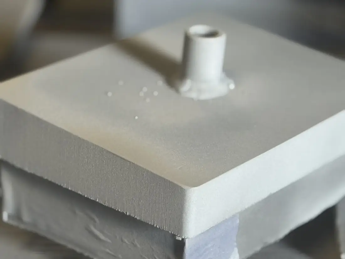 Close-up of a painted steel bearing plate corner with a welded stud
